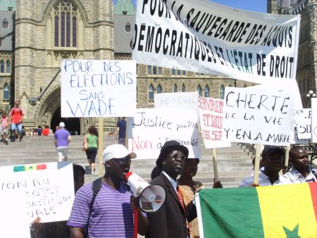 Protestors hold a banner reading "Pour la sauvegarde des acquis democratiques et l'etat de droit" (Safeguard the democratic gains and rule of law).