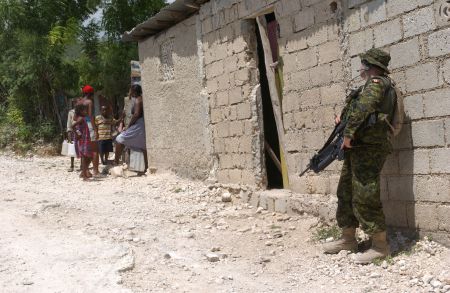 A Canadian soldier conducts a house search in 2004. Canadian Forces often provided backup for HNP raids, which killed thousands of political dissidents.