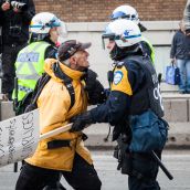A older protester and Riot Police clash during Montreal's 18th annual Protest against Police Brutality.