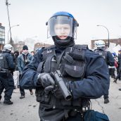 A Montreal Riot Police officer holding a rubber bullet hand gun at Montreal's 18th annual Protest against Police Brutality.